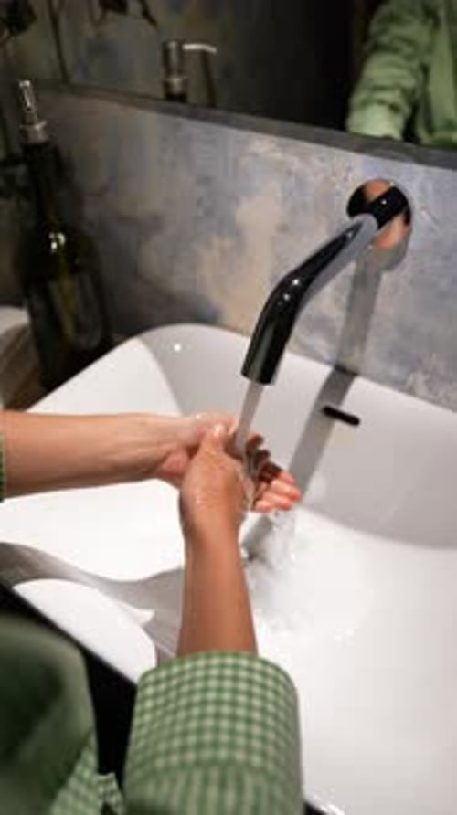 An Aerial View Captures the Scene of Female Hands Under a Water Faucet