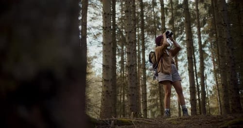 Woman Hiker Looking Through Binoculars in Forest