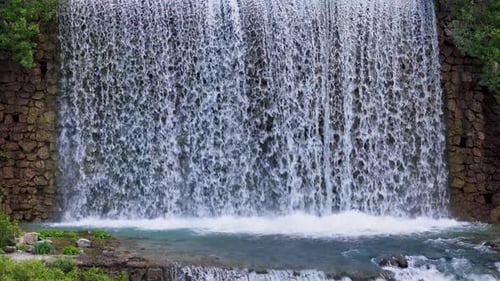 Picturesque Waterfall Cascading Down Rocky Mountain Landscape