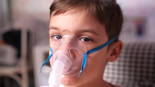 Boy Wearing Nebulizer Mask for Respiratory Treatment