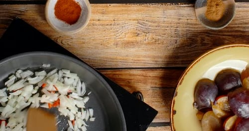 Adding Onions and Peppers to Pan for Cooking