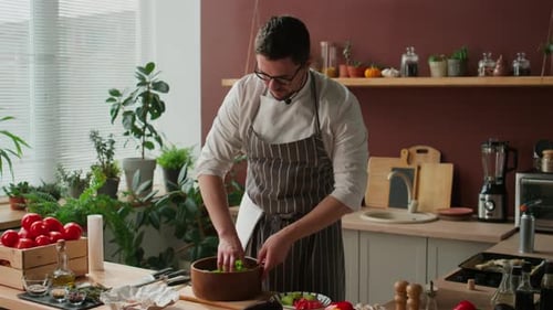 Male Chef Mixing Arugula Salad with Hands