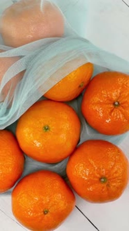 Ripe Juicy Tangerines in Ecofriendly Grid Rotate on White Background