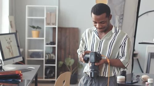 Adult Smiling Holding a Camera Indoors