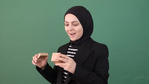 Young Woman Opens a Small Cardboard Box