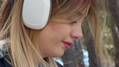 Woman Listening to Music with Wireless Headphones Outdoors