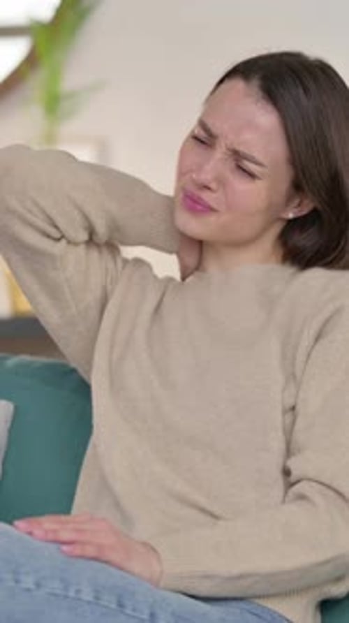 Woman Massaging Her Sore Neck on the Couch