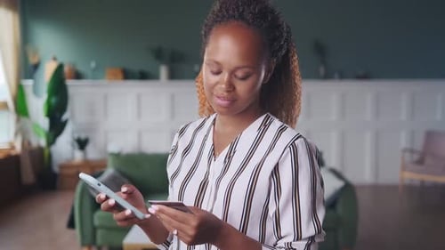 Woman Using Smartphone and Credit Card Indoors