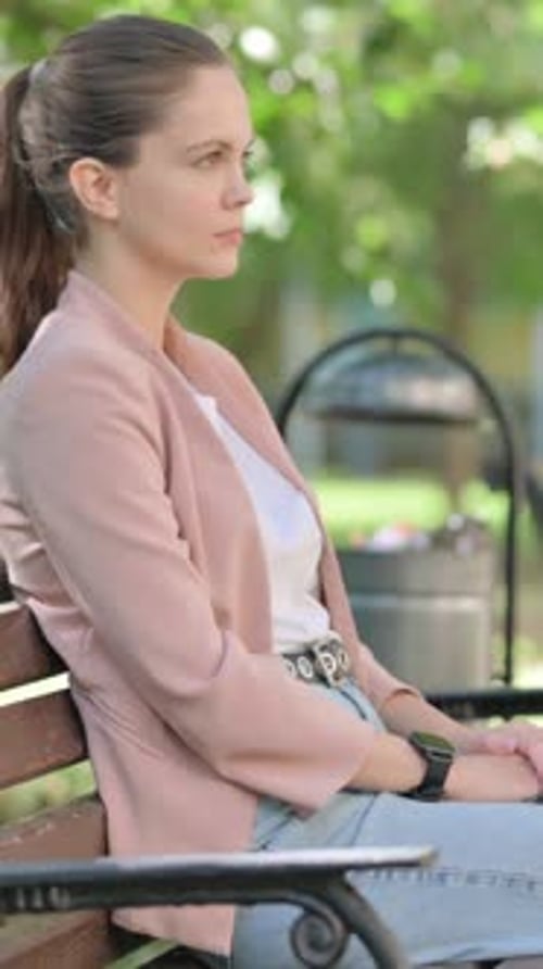 Mulher de negócios casual em pé e saindo depois de se sentar ao ar livre no banco