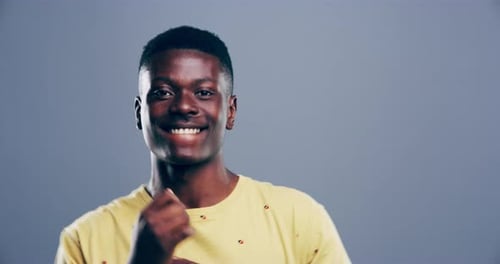 Smiling Young Adult gesturing enthusiastically on gray background