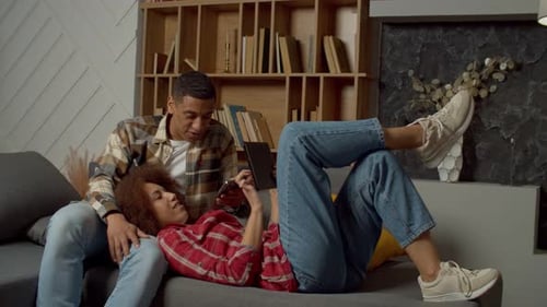 Couple Relaxing on Couch with a Smartphone