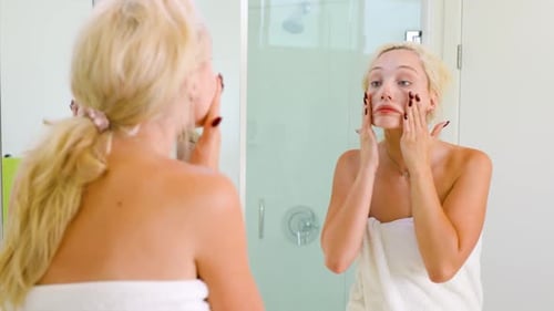 Woman with Blonde Hair Applies Product to Face