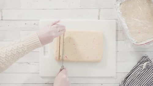 Hands Cutting Cookie Dough on Cutting Board