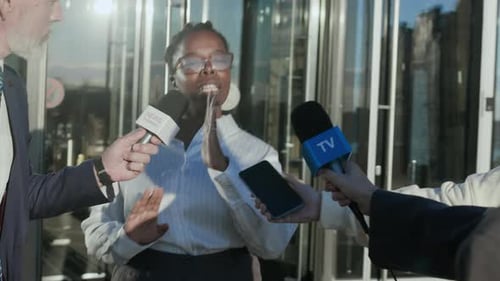 Woman Speaks at Press Conference in Urban Setting