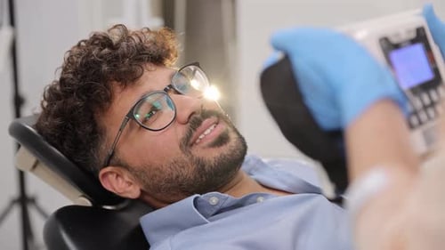 Man Receiving a Dental Checkup in a Modern Clinic