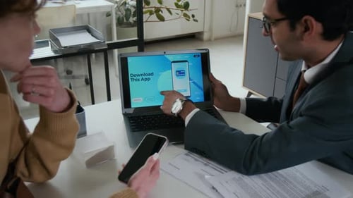 Man in Suit and Glasses Talking About New App to his Colleague in Bank Office