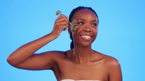 Skincare, jade roller and black woman in studio for wellness, anti aging