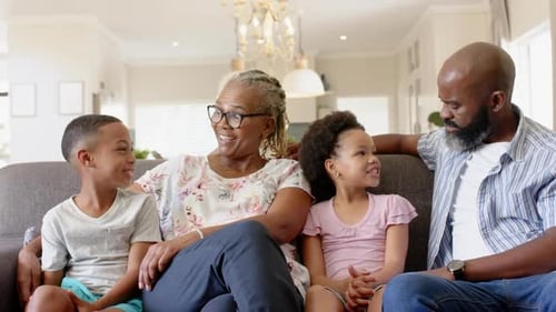 Happy Family Laughing Together on Sofa Indoors