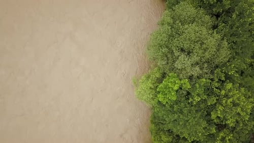 Aerial View of Wide Dirty River with Muddy Water in Flooding Period During Heavy Rains in Spring