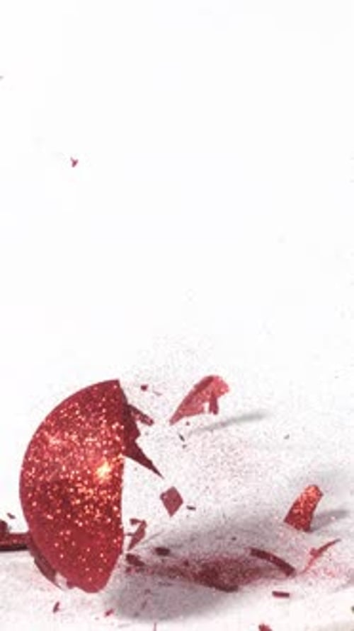 Christmas ornament falls and shatters in slow motion. Vertical Video.