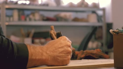 Close-up of a man's hands sketching a design on paper.