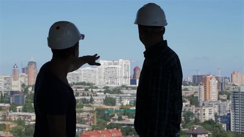 El constructor señala con entusiasmo hacia un impresionante horizonte de edificios de gran altura