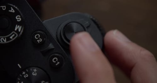 Finger pressing shutter release button on camera taking picture, close up