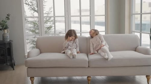 Two Girls Sitting and Laughing on a Couch