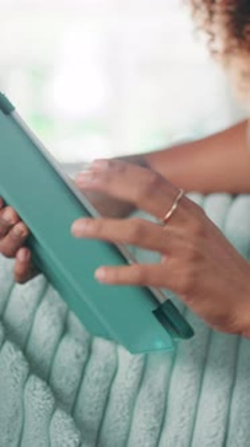 Young Woman Using Tablet Indoors on Comfortable Couch
