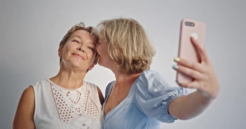 Mother and Daughter Take Selfie Together Indoors