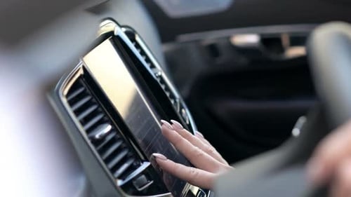 Une jeune femme met en place une application GPS dans une voiture moderne pour une aventure en voiture