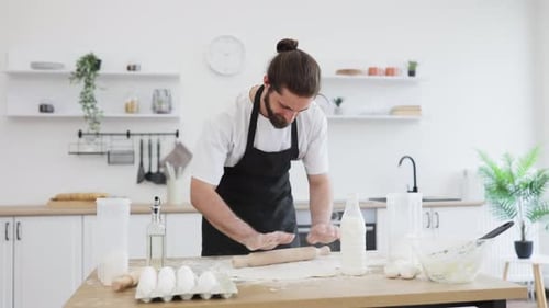 Man Preparing Dough on Wooden Table in Home Kitchen Bakery