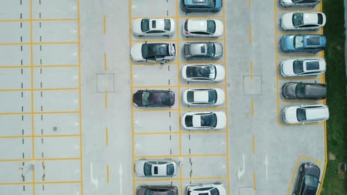 Luftaufnahme eines Parkplatzes von oben nach unten mit Autos in verschiedenen Farben, Kamera bewegt sich vorwärts
