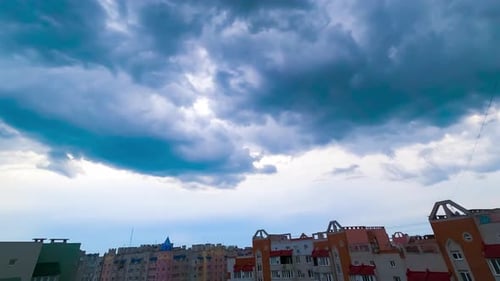 Blue clouds move over the houses in residential area. Timelapse.