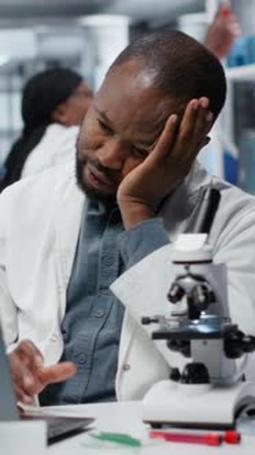 Frustrated Scientist Working in a Lab with Microscope