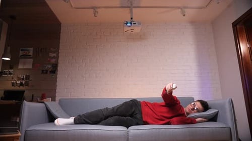 Man Reclining on Sofa with Remote in Hand