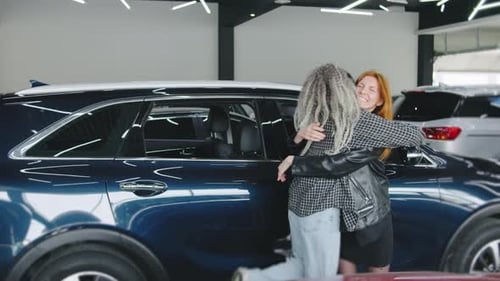 Two Women Celebrate New Car in Dealership