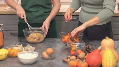 Lesbian Family Cooking Together Pumpkin Pie for Thanksgiving Holiday Dinner
