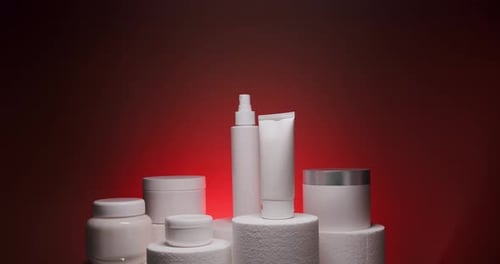 White Bottle and Tubes for Cosmetics on a Red Background in Studio