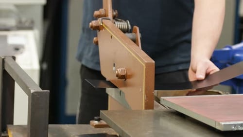 Arbeiter mit einer Guillotinenschere zum Schneiden von Blechen in einer industriellen Umgebung, Nahaufnahme