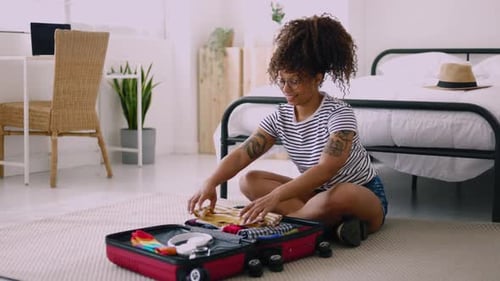 Young Woman Packing Suitcase in Bright Bedroom