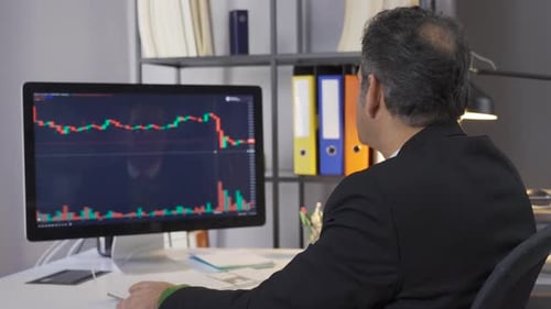 Mature businessman researching and analyzing stock market data.