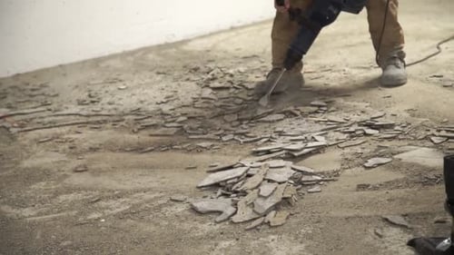 Worker Uses Jackhammer to Break Apart Tiled Floor