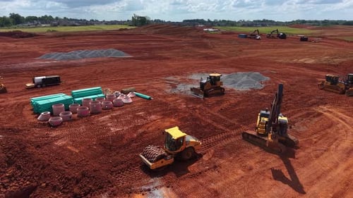 Una excavadora baila con un adoquín en un sitio de construcción recientemente desarrollado