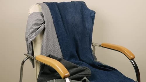 Clothing Piling Onto Leather Chair in Studio