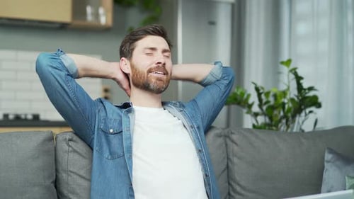 Content Man Relaxing at Home on Couch