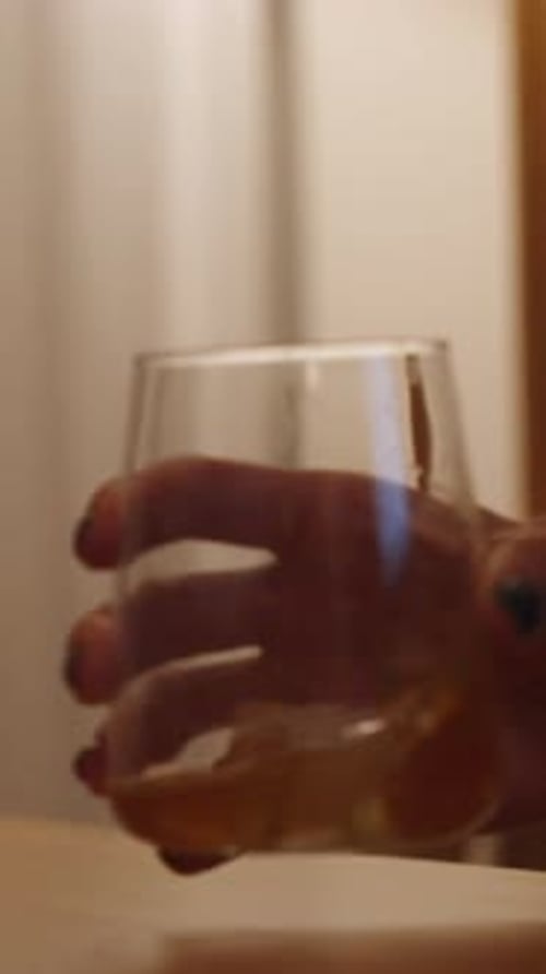 Woman Drinking a Yellow Liquid from a Glass