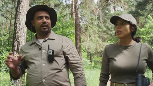 Two Diverse Wildlife Protection Officers Walking in Forest and Talking