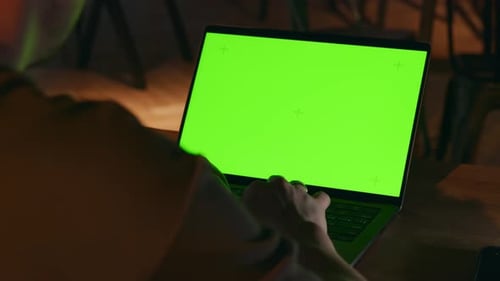 A Green Screen on the Laptop Display The Hacker Prints the Program Code