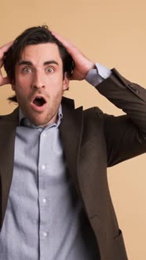 Stunned Businessman with Opened Mouth in Brown Studio